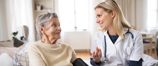 happy nurse and senior woman
