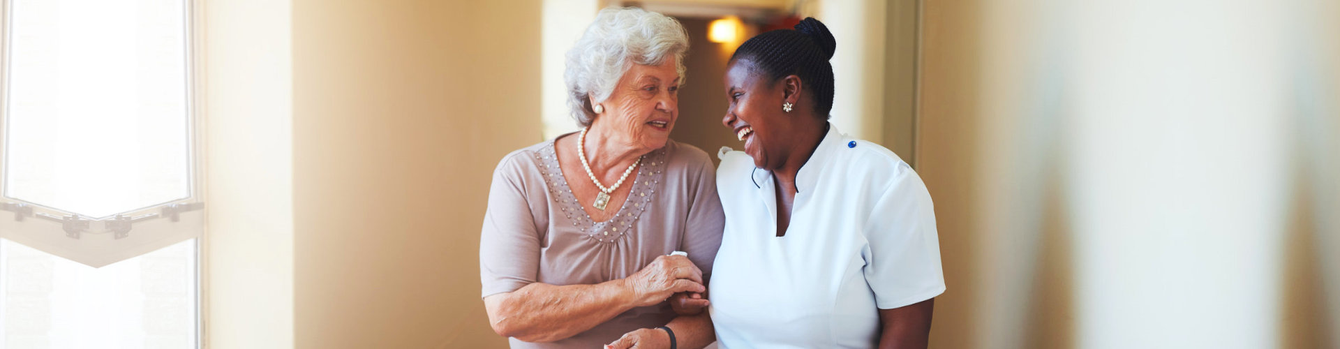 happy senior woman walking with her caregiver