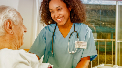 happy nurse talking to a senior man