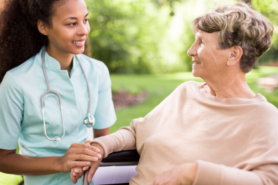 nurse and senior woman on wheelchair smiling